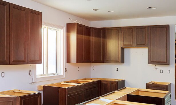 A kitchen under construction with new cabinets being installed.