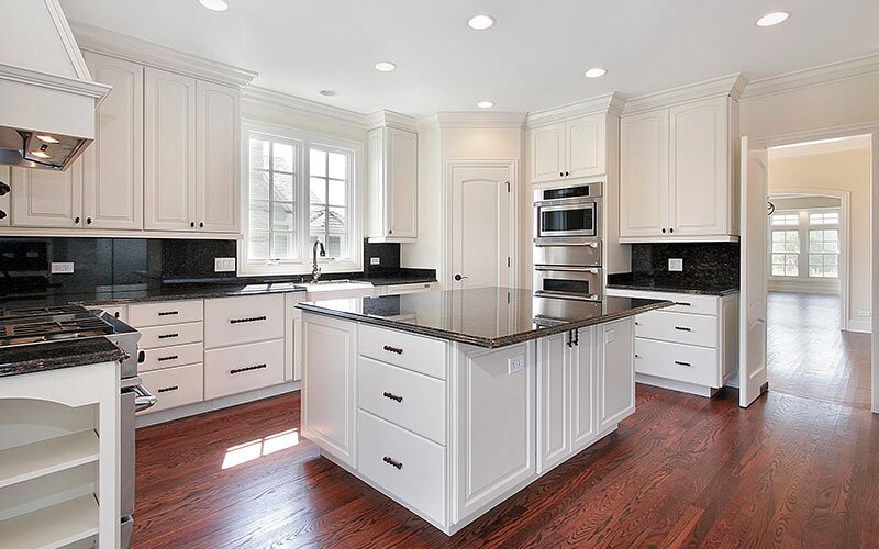 New kitchen with a large center island and white cabinets.