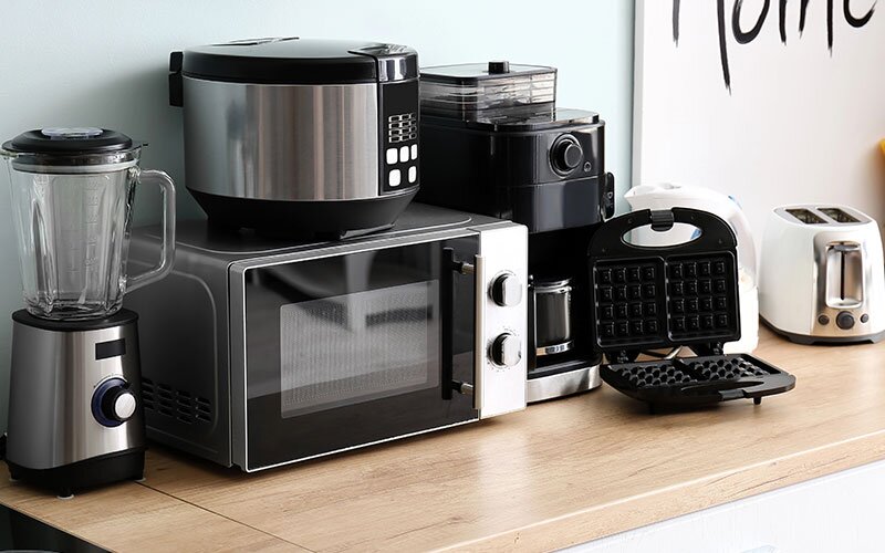 A group of small appliances on a wooden countertop.