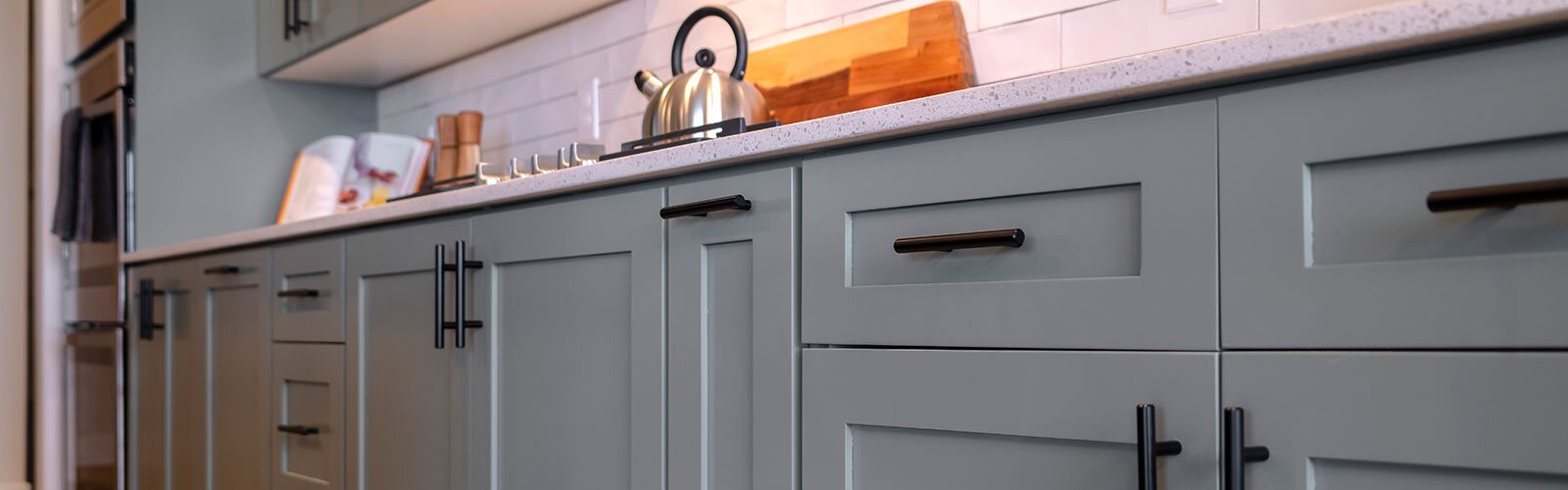 Close-up of a kitchen cabinet with black hardware.