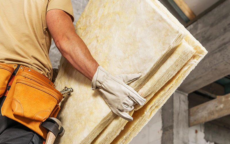A man holding 3 pieces of insulation. 