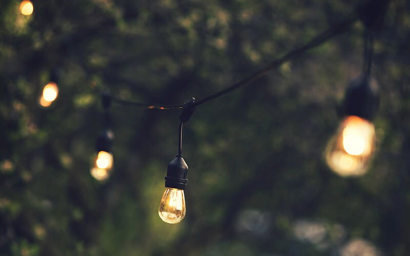 String of lights hanging outside in a backyard.