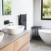 A bathroom with double sinks and a tub.