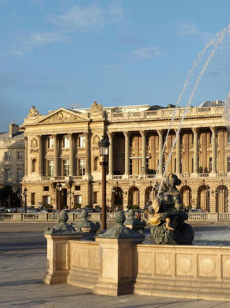Pool area with blue lounge chairs with matching umbrellas