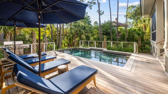 Pool area with blue lounge chairs with matching umbrellas