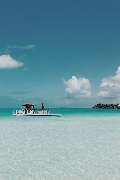 Pool area with blue lounge chairs with matching umbrellas