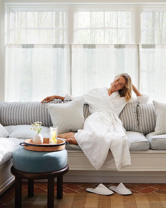 Woman relaxing on a couch in a robe and slippers