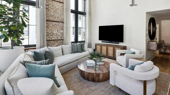 White furniture arranged in a circle in front of a media center with a wall-mounted flat screen tv