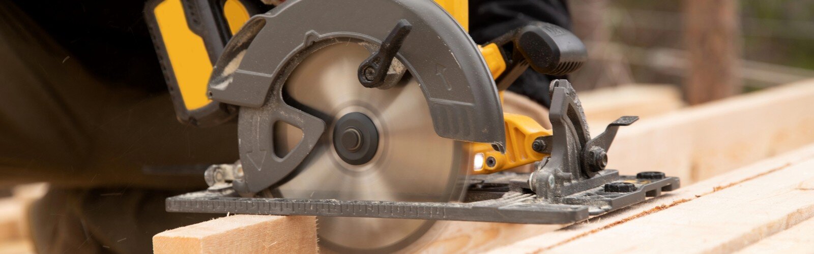 Builder uses portable circular saw tool to cut wood