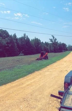 Bush hogging equipment cutting an open field in Middle Tennessee
