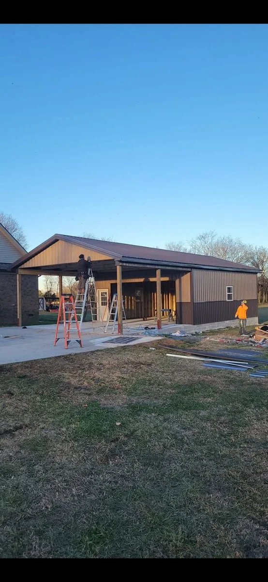 Metal roof and wall panels being installed on a barn-style building in Middle Tennessee