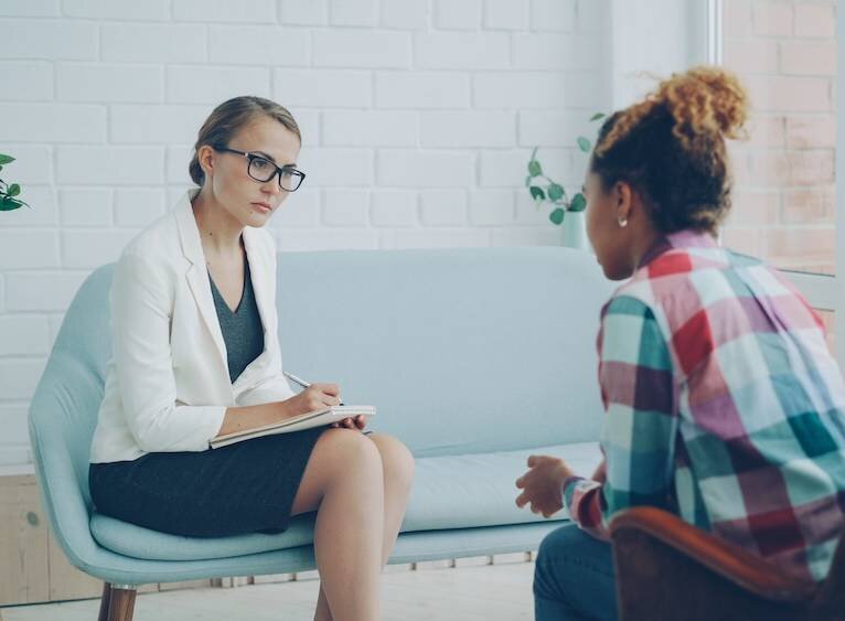 Patient thoughtfully speaking with psychotherapist