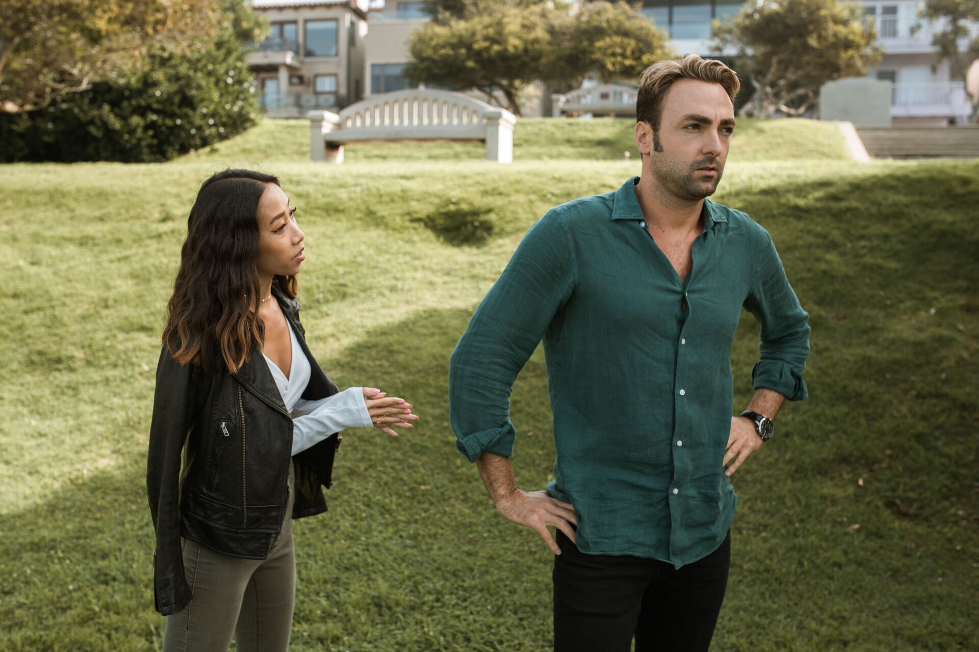 An upset man faces away from a woman who is trying to speak with him