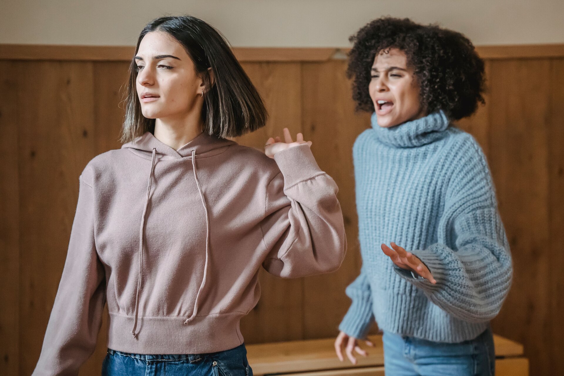 A woman walks away from another woman during an argument