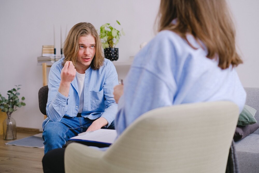 Patient thoughtfully speaking with psychotherapist