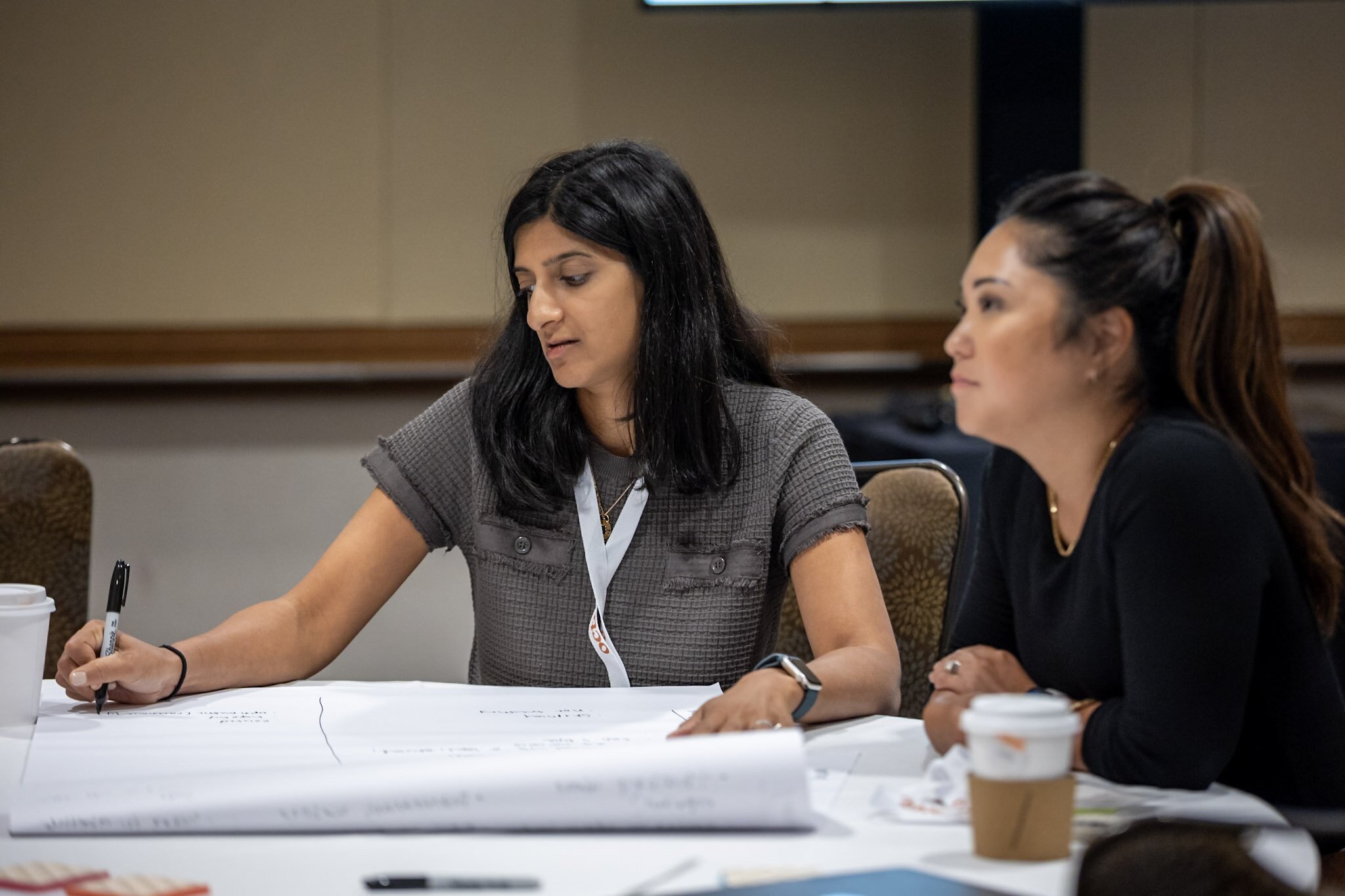 A smiling woman outdoors with a blue sky in the background.