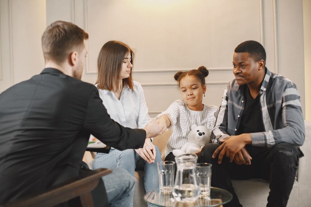 Two adults and a child at a therapist's office