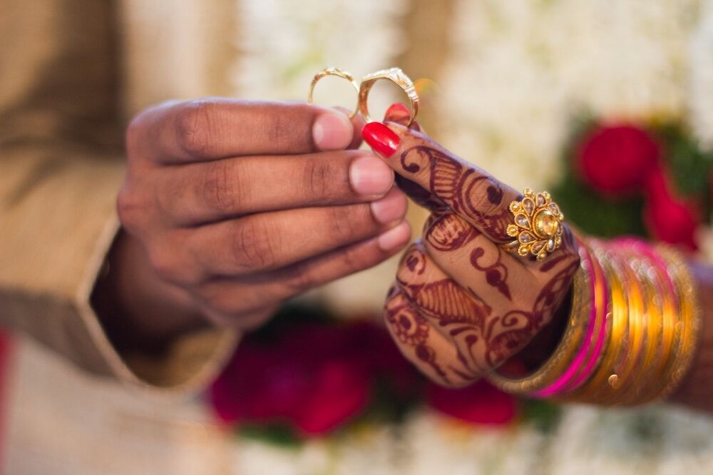 Two hands holding wedding rings together
