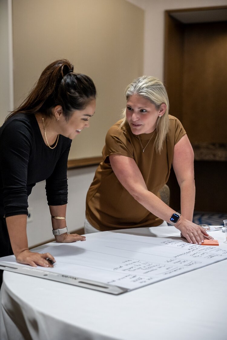 A smiling woman outdoors with a blue sky in the background.