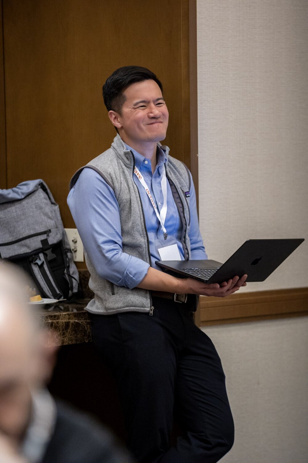 A smiling woman outdoors with a blue sky in the background.
