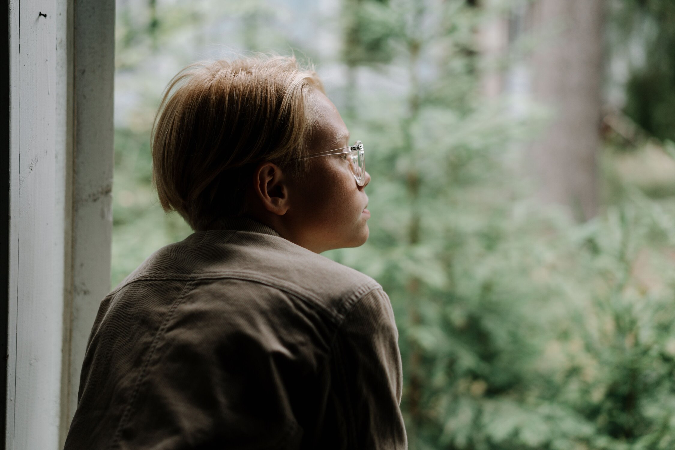 A woman with glasses looking off to the right silently