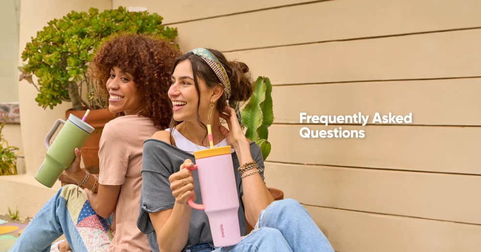 Two women enjoying drinks from pink and green Owala tumblers while relaxing outdoors.