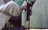 A person sitting in a chair holding a green FreeSip Sway by the handle