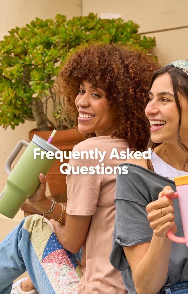 Two women enjoying drinks from pink and green Owala tumblers while relaxing outdoors.