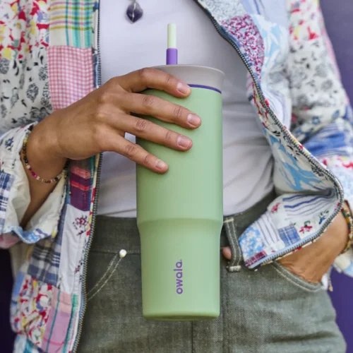 a person holding a green 24oz tumbler