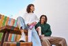 Male and female holding pink, tan, and light grey 24oz Owala tumblers, sitting on a bench.