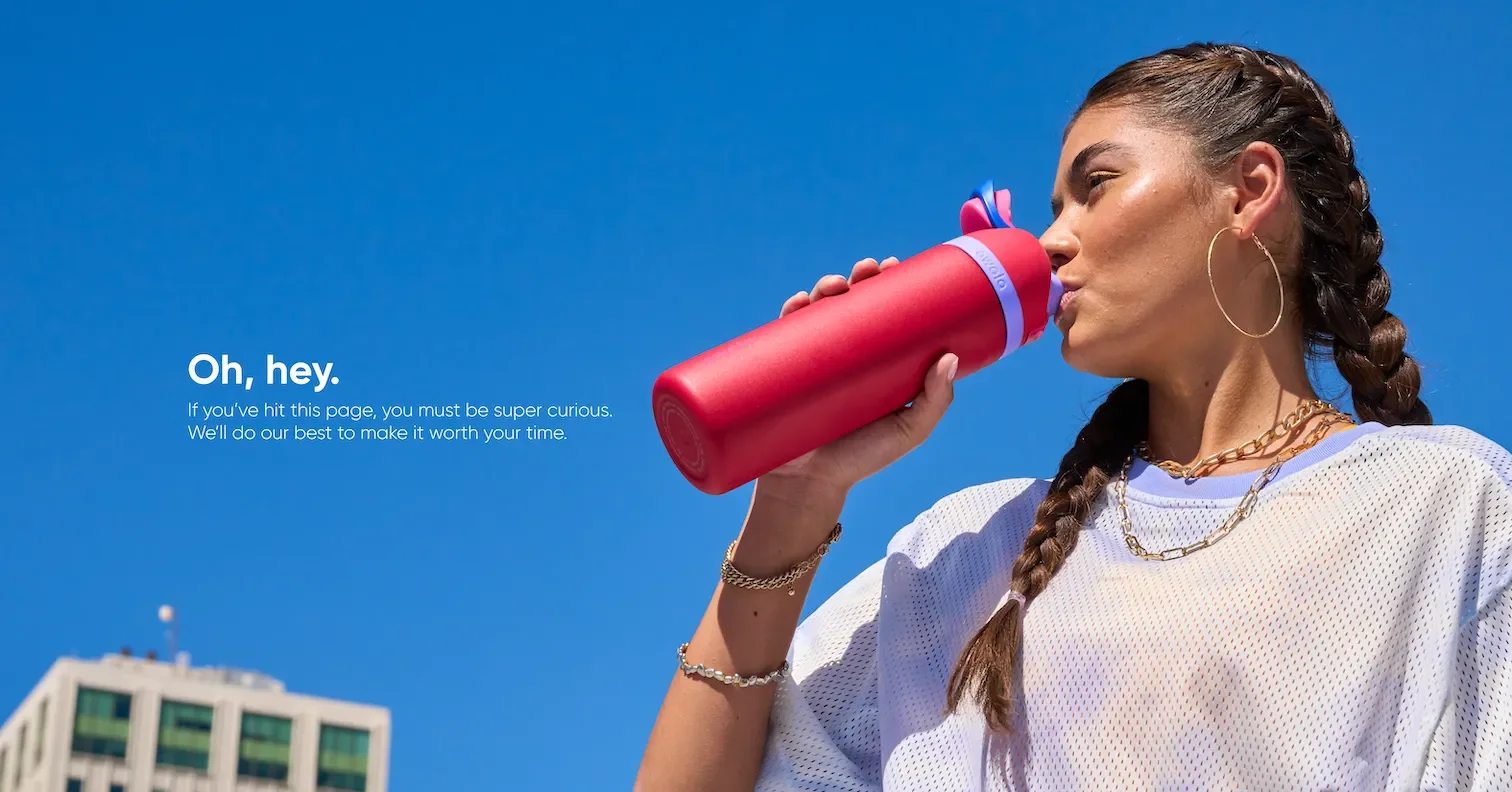 Girl drinking from a red 24oz Owala FreeSip water bottle, highlighting its stylish and functional design.