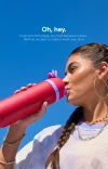 Girl drinking from a red 24oz Owala FreeSip water bottle, highlighting its stylish and functional design.