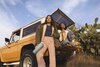 Two women sitting on a tailgate holding FreeSip Sway and Tumbler products