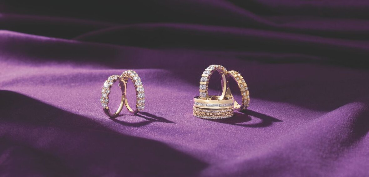 White and yellow gold diamond wedding bands styled on lace fabric, showcasing elegant bridal ring designs by Wedding Bands & Co. in Chicago