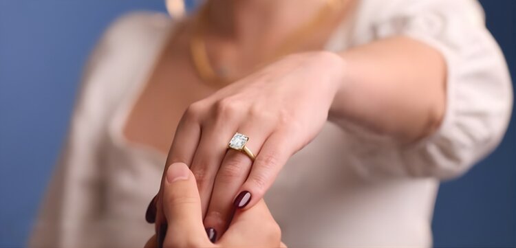 Close-up of emerald cut diamond engagement ring highlighting hall of mirrors effect and clean lines