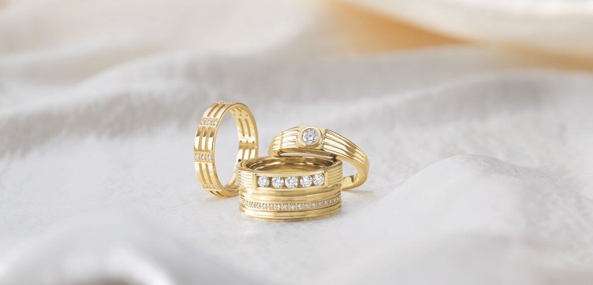 White and yellow gold diamond wedding bands styled on lace fabric, showcasing elegant bridal ring designs by Wedding Bands & Co. in Chicago