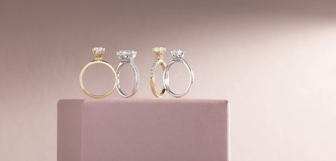 White and yellow gold diamond wedding bands styled on lace fabric, showcasing elegant bridal ring designs by Wedding Bands & Co. in Chicago