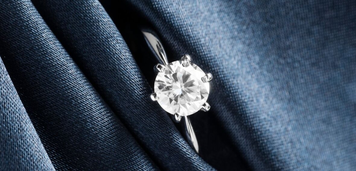 White and yellow gold diamond wedding bands styled on lace fabric, showcasing elegant bridal ring designs by Wedding Bands & Co. in Chicago