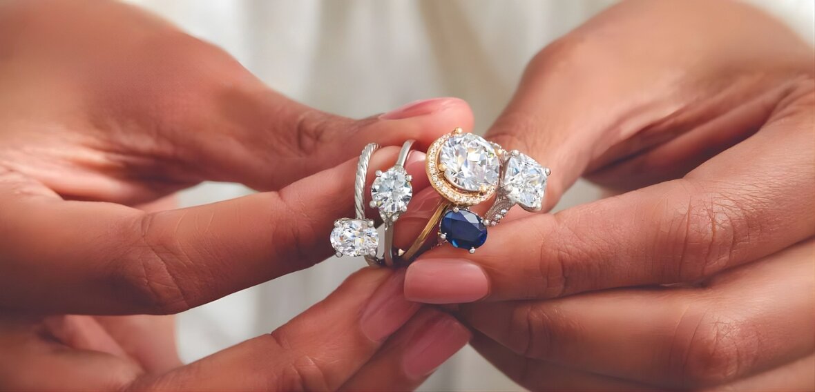 Gold engagement ring with pavé diamond band stacked with matching wedding bands on white background