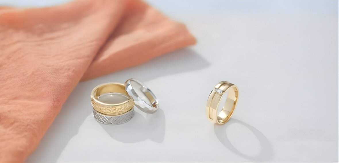 White and yellow gold diamond wedding bands displayed on lace fabric representing diverse marriage traditions