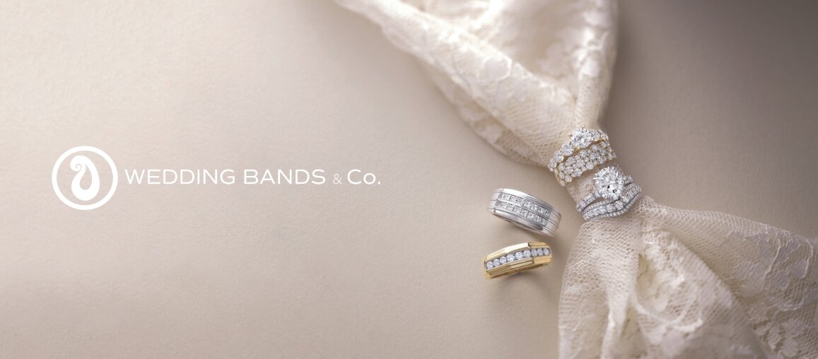 White and yellow gold diamond wedding bands styled on lace fabric, showcasing elegant bridal ring designs by Wedding Bands & Co. in Chicago