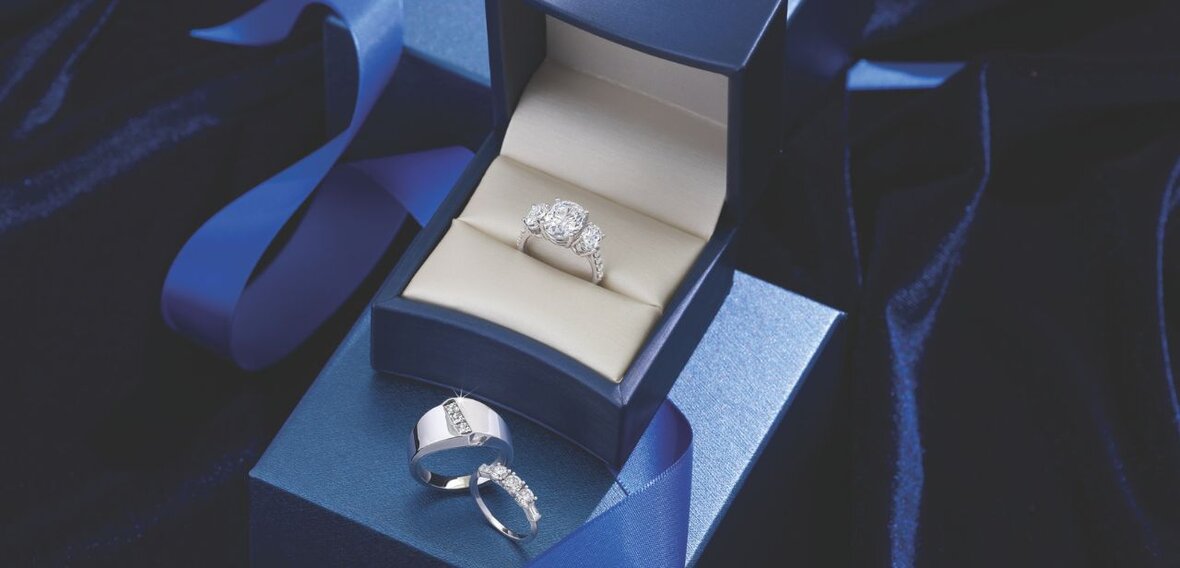 White and yellow gold diamond wedding bands styled on lace fabric, showcasing elegant bridal ring designs by Wedding Bands & Co. in Chicago