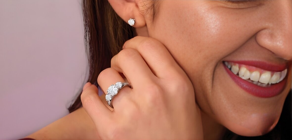 Gold solitaire engagement ring with pavé diamond band demonstrating correct ring fit on finger