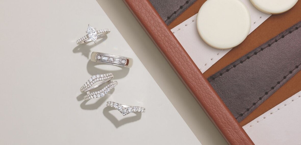 White and yellow gold diamond wedding bands styled on lace fabric, showcasing elegant bridal ring designs by Wedding Bands & Co. in Chicago