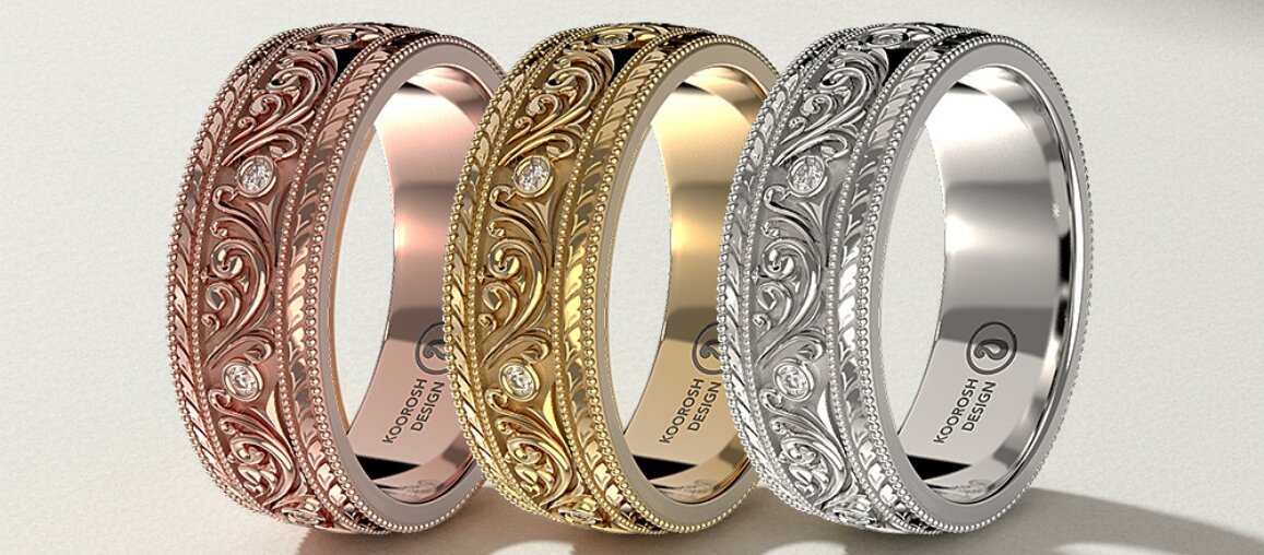 Three vintage-style engraved wedding bands in rose gold, yellow gold, and white gold featuring ornate scrollwork details and small round diamonds set into the band.