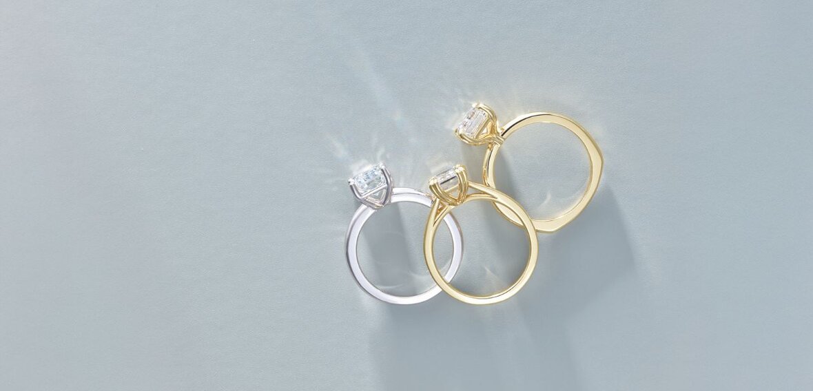 White and yellow gold diamond wedding bands styled on lace fabric, showcasing elegant bridal ring designs by Wedding Bands & Co. in Chicago