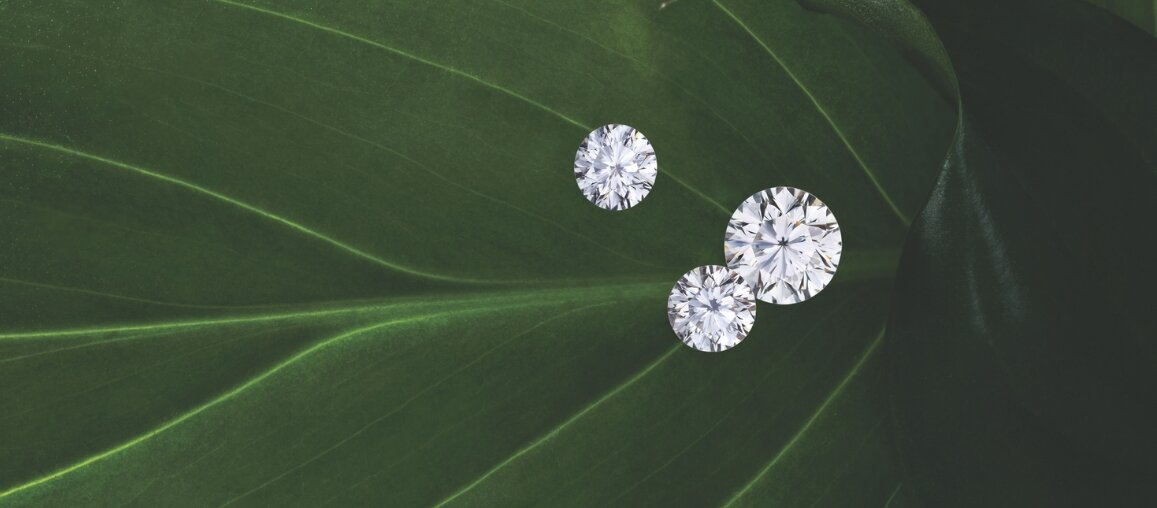 Loose marquise cut lab-grown diamonds in varying sizes displayed on a green background