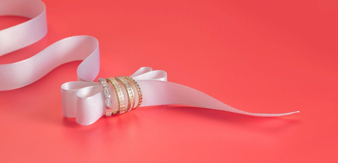 White and yellow gold diamond wedding bands styled on lace fabric, showcasing elegant bridal ring designs by Wedding Bands & Co. in Chicago