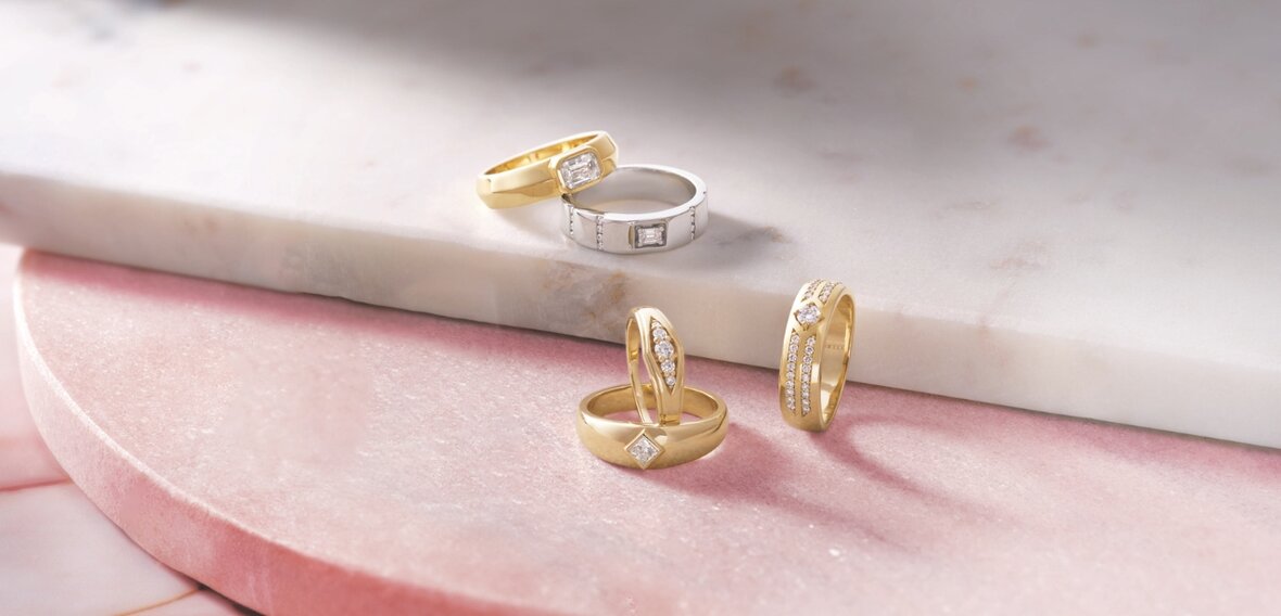 White and yellow gold diamond wedding bands styled on lace fabric, showcasing elegant bridal ring designs by Wedding Bands & Co. in Chicago