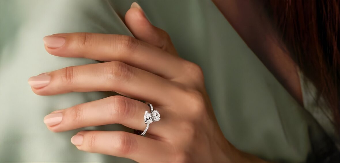 Gold solitaire engagement ring on ring finger with wedding band showing proper finger placement